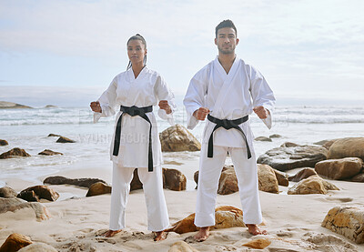 Buy stock photo Portrait of two young martial artists practicing karate on the beach