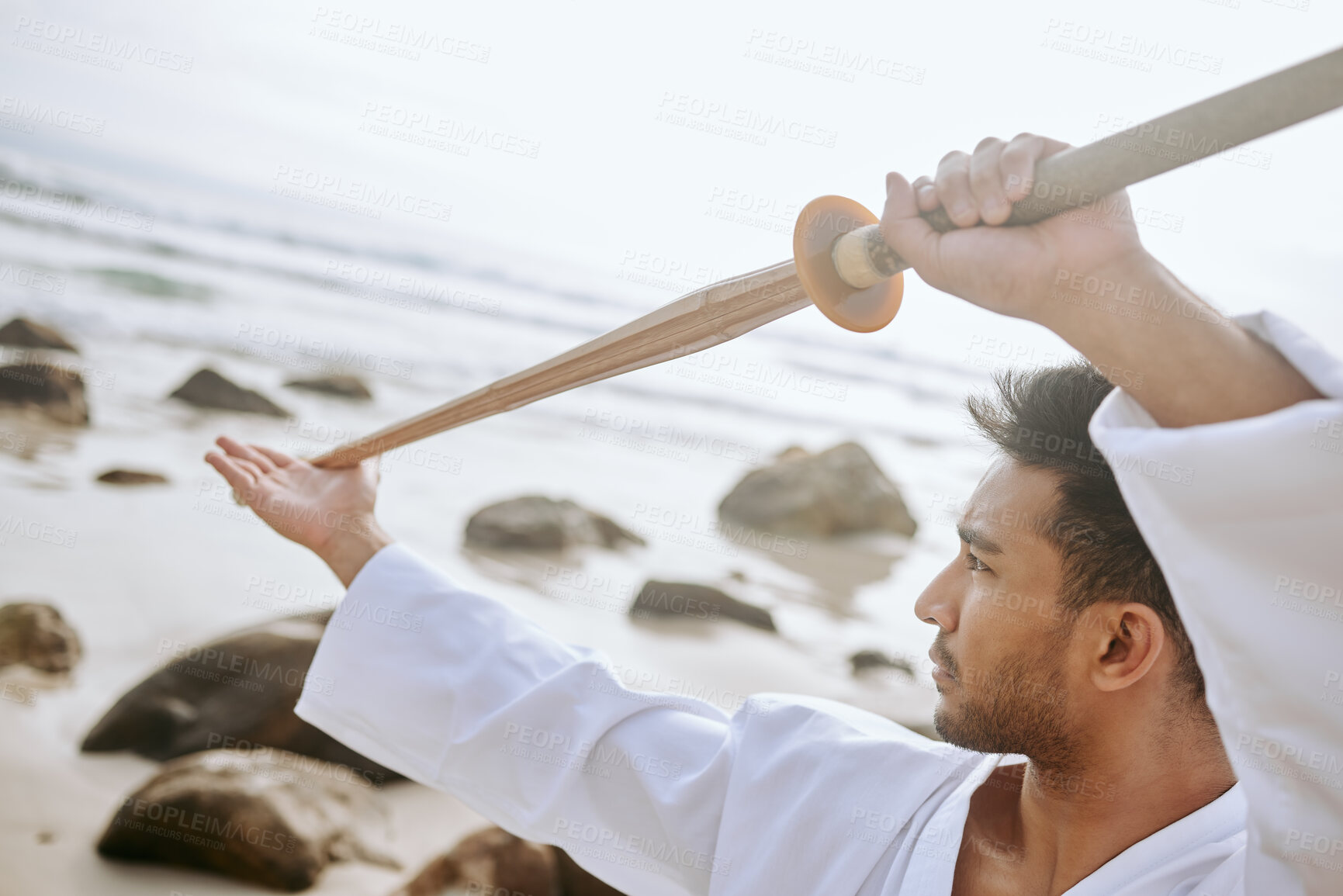 Buy stock photo Martial arts, beach and man with weapon for training, practice and learning aikido, karate and jiujitsu. Sports, nature and person with bokken by ocean for fitness, exercise and workout for taekwondo