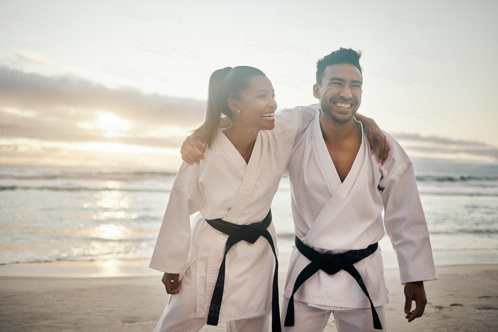 Buy stock photo Happy people, friends and karate with hug on beach for martial arts training or self defense in nature. Young man and woman with smile or uniform on outdoor ocean coast for day of taekwondo together