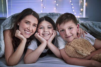 Buy stock photo Shot of a young mother spending time with her children before bedtime at home