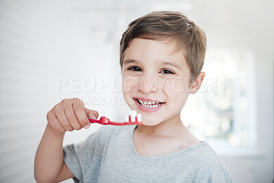 Buy stock photo Shot of a little boy brushing his teeth in a bathroom at home