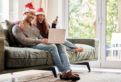 Buy stock photo Shot of a young couple doing online shopping while wearing Christmas hats at home