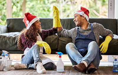 Buy stock photo Shot of a young couple giving each other a high five after cleaning at home