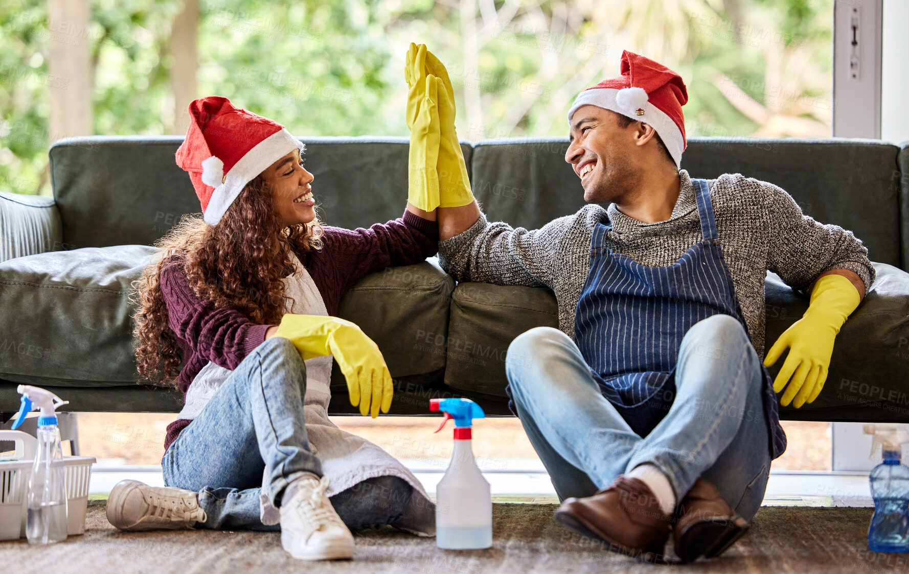 Buy stock photo Shot of a young couple giving each other a high five after cleaning at home