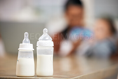 Buy stock photo Baby bottle, milk and parent with child for healthcare, wellness or home love with product on living room table. Growth, development and liquid, food or drink for infant or newborn kid, mom or person