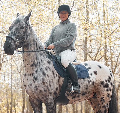 Buy stock photo Shot of an attractive young woman riding with her horse outside