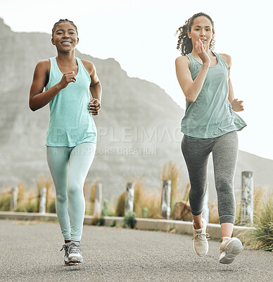 Buy stock photo Shot of two young women on a run in the morning