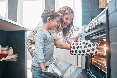 Buy stock photo Shot of a little boy and his mother sitting in front of the oven