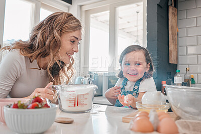 Buy stock photo Shot of a mother and daughter baking in the kitchen at home