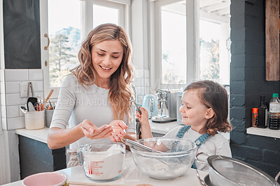 Buy stock photo Shot of a mother and daughter baking in the kitchen at home