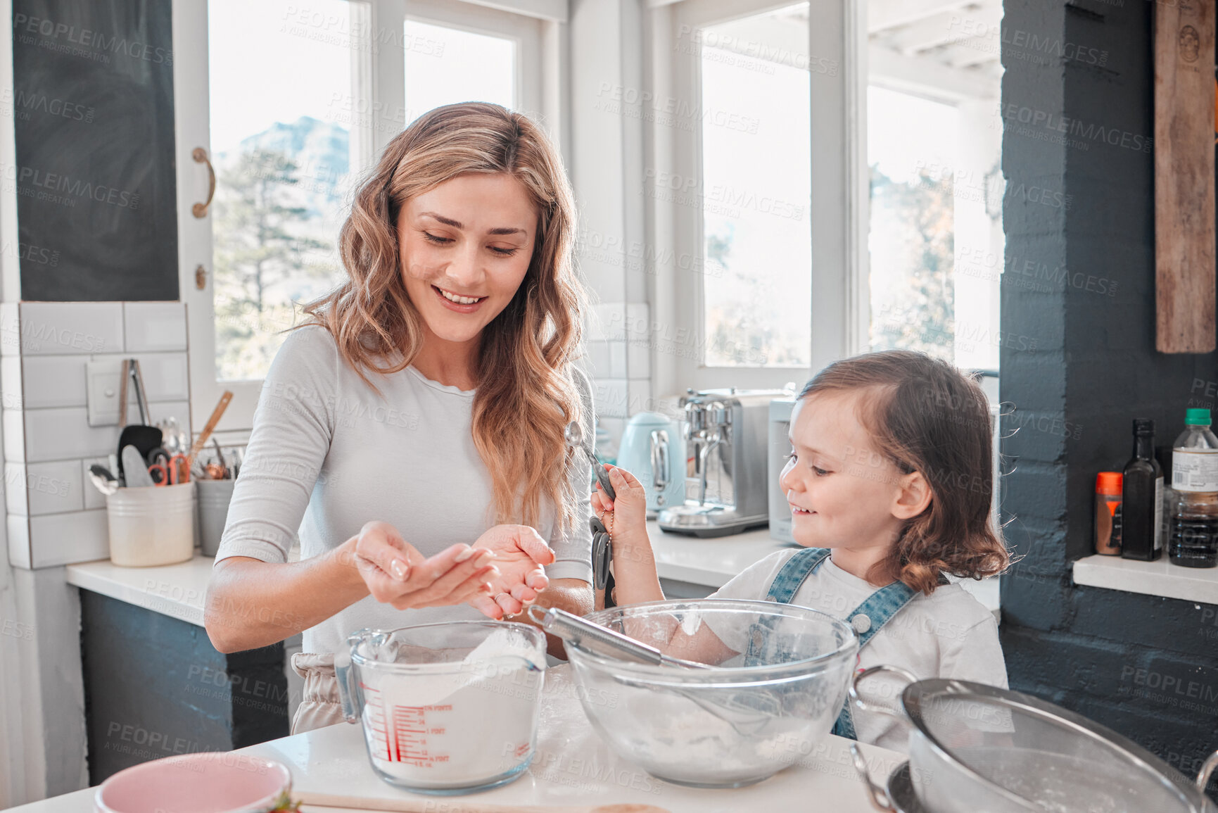 Buy stock photo Shot of a mother and daughter baking in the kitchen at home