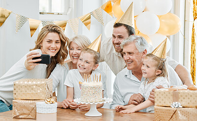 Buy stock photo Shot of a happy family taking selfies while celebrating a birthday at home