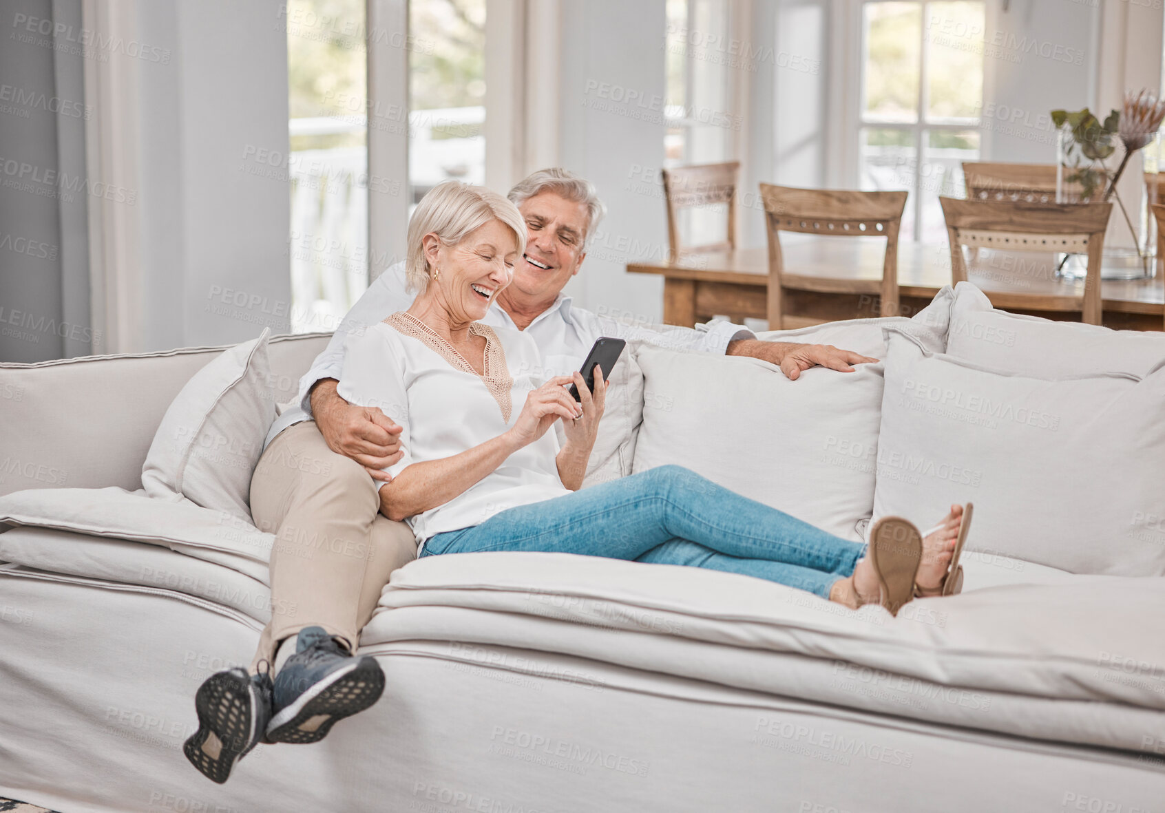 Buy stock photo Senior couple, smile and phone on sofa for social network, funny gif and healthy marriage with love in home. Happy, mature woman and man with mobile for retirement, online and bonding together