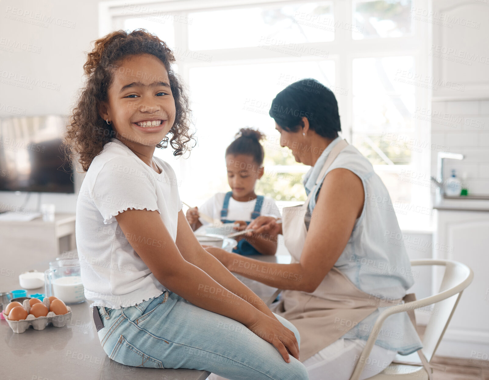 Buy stock photo Shot of a mature woman baking with her granddaughters