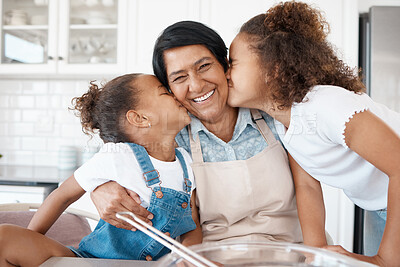 Buy stock photo Shot of two sisters kissing their grandmother while baking with her