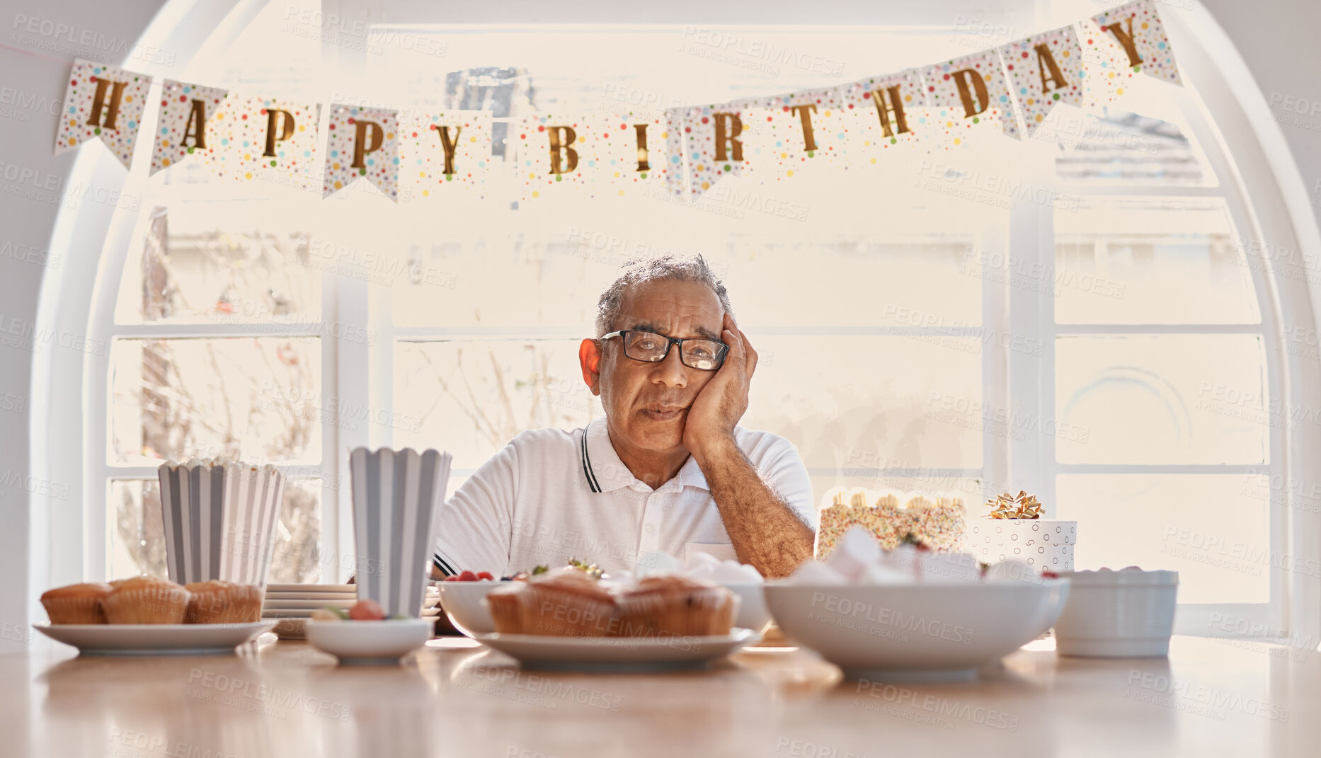 Buy stock photo Party, unhappy and senior man with birthday in dining room for loneliness, upset or getting older. Cake, decorations and elderly person with snacks for retirement, bored or celebrating alone in home