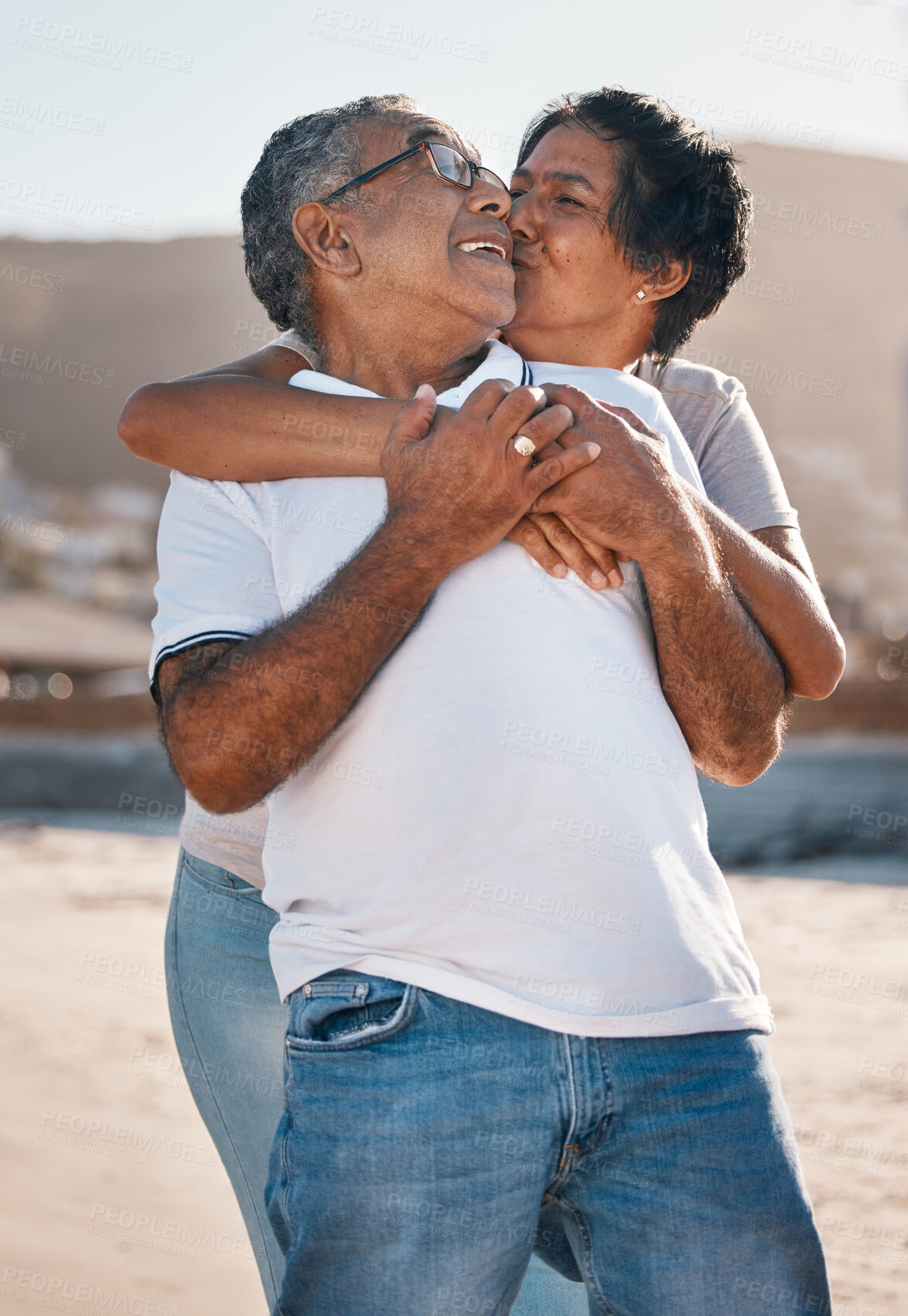 Buy stock photo Outdoor, kiss and senior couple at beach with hug or happiness, affection or summer getaway trip. Ocean, married woman and elderly man by coast for love, adventure or holiday vacation in Bahamas