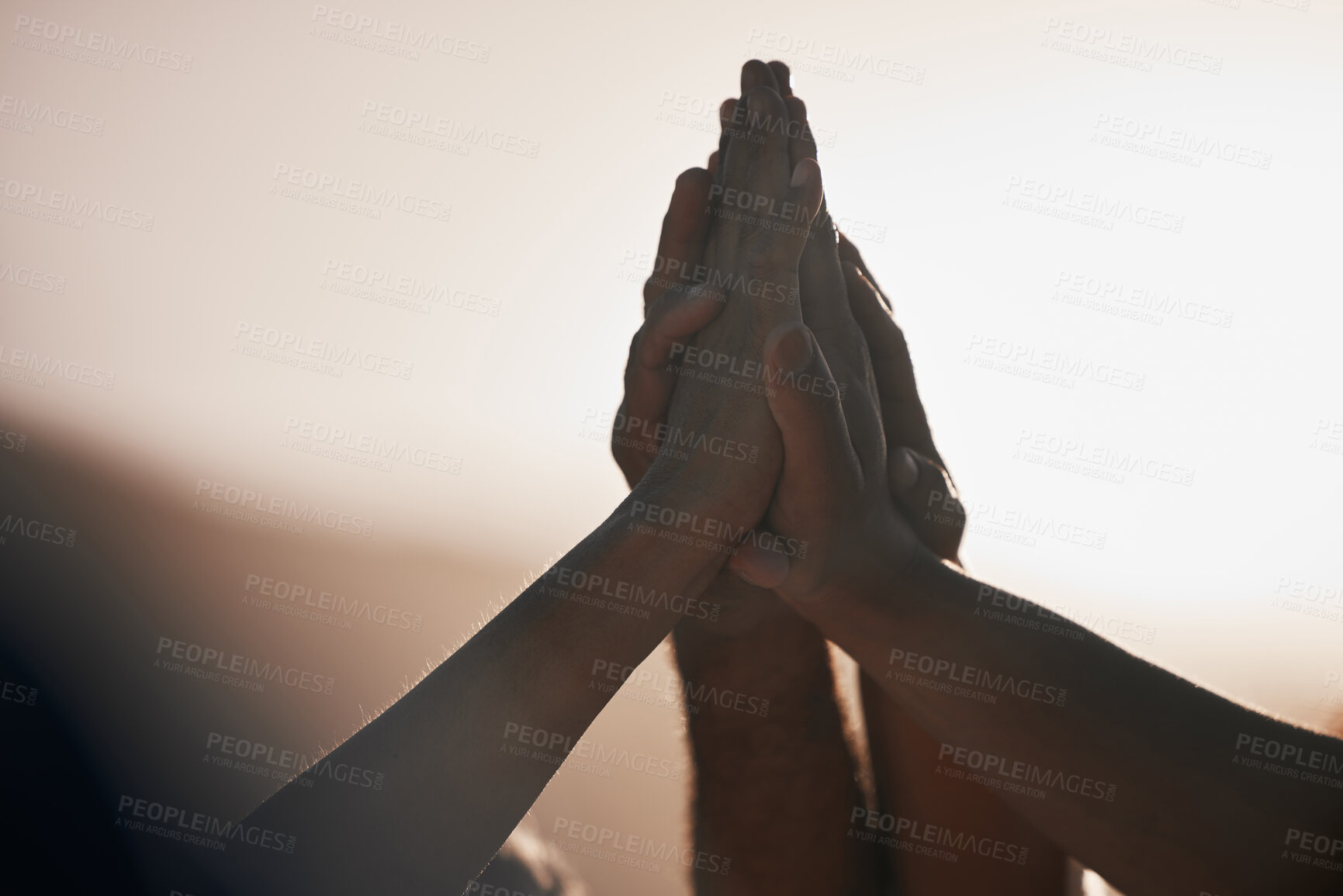 Buy stock photo Shot of a group of unrecognizable people giving each other a high five outside