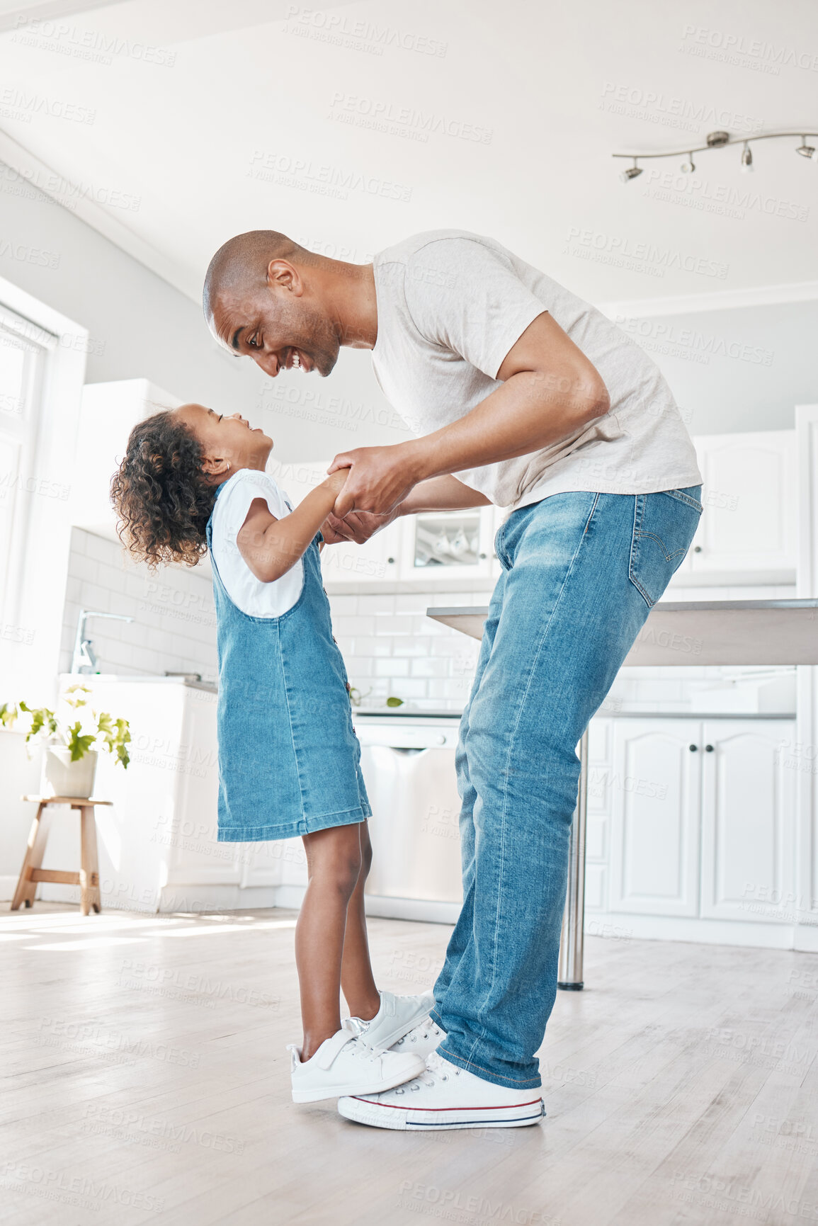 Buy stock photo Dad, girl and happy dancing together for love relationship, weekend entertainment and bonding time in home. Smile, daughter and dance on father feet for learning support and energy for teaching steps