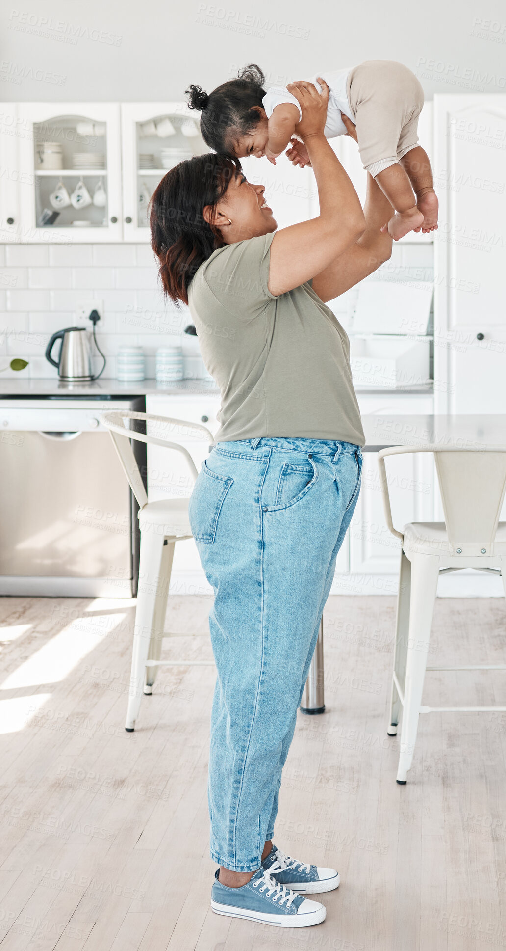 Buy stock photo Mom, happy and lifting baby with love for bonding together, security and healthy growth in family home. Mama, smile and holding newborn girl for care, safety and support for development in kitchen