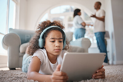 Buy stock photo Shot of a young girl using a digital tablet while her parents argue