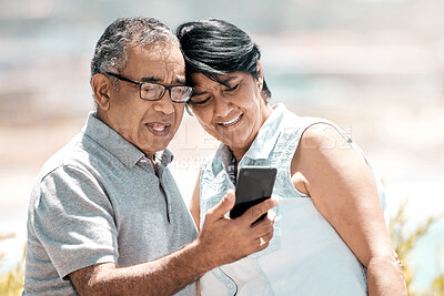 Buy stock photo Shot of a senior couple using a phone in nature