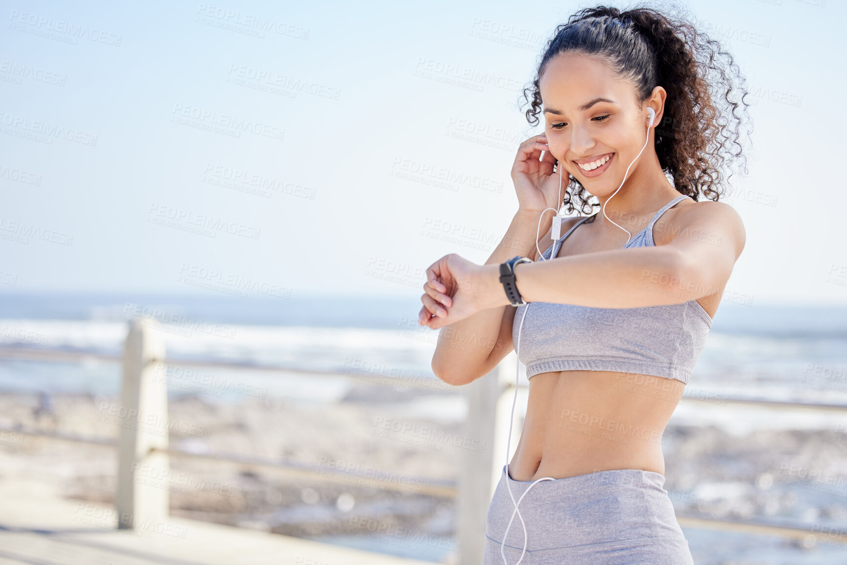 Buy stock photo Time, check and woman with earphones, outdoor and listen to music, streaming and smile for exercise. Nature, runner and athlete with watch, happy and ready for training, radio or podcast for workout