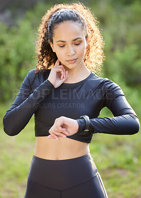 Buy stock photo Shot of a beautiful woman checking her vitals while out having her morning workout outside