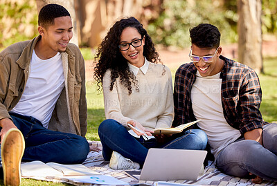 Buy stock photo Shot of a group of students studying together while sitting on the grass outside
