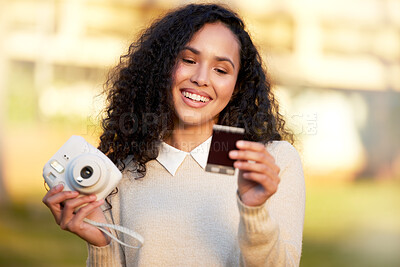 Buy stock photo Shot of a young woman taking a picture with a camera while standing outside