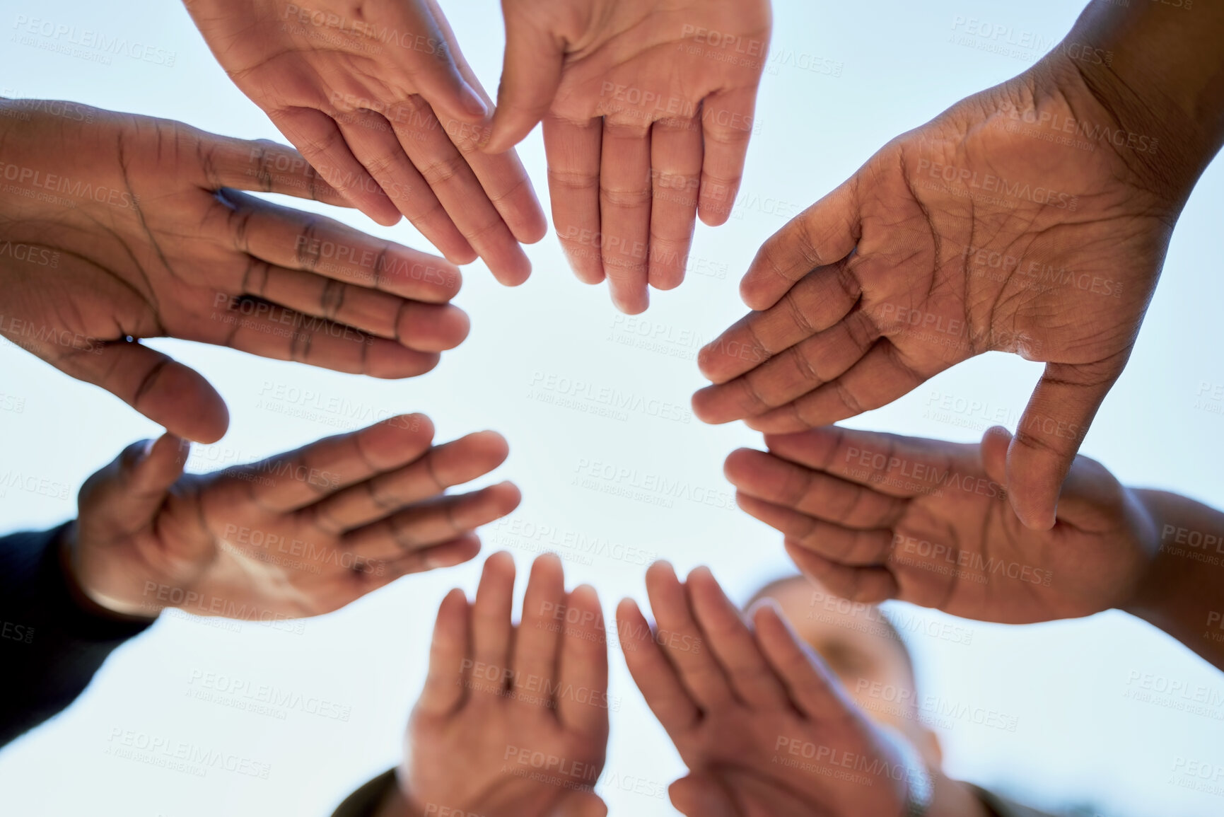 Buy stock photo Shot of a group of unrecognizable students joining hands while standing outside