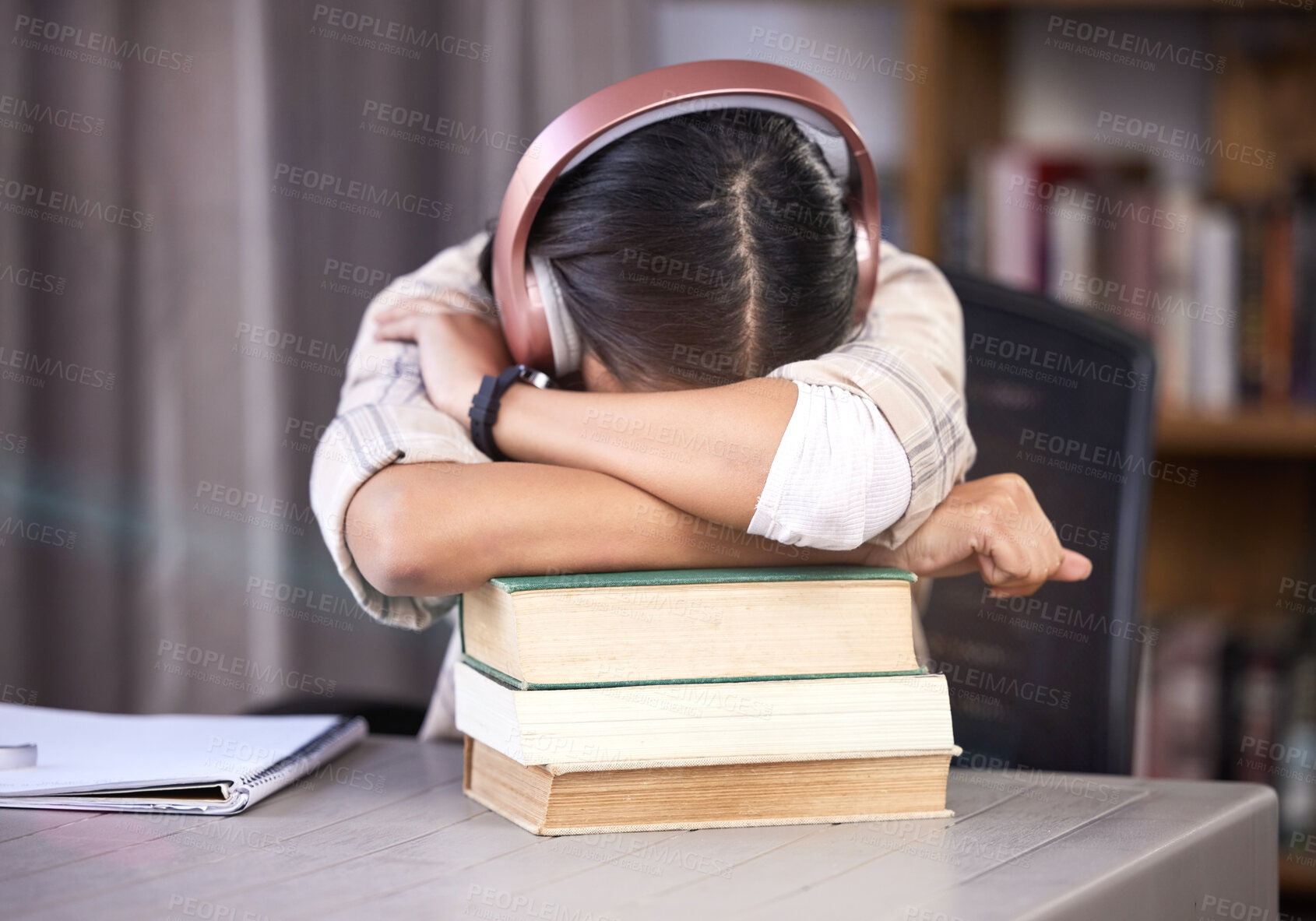 Buy stock photo Headphones, books and girl with sleeping in library for studying, burnout and knowledge for exam. University, student and tired with rest on table for scholarship, education or deadline of assignment