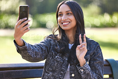 Buy stock photo Shot of a beautiful young student using her phone while sitting outside