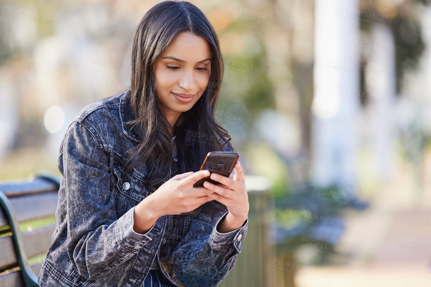 Buy stock photo Young woman, smile and smartphone typing outdoor in park for social media and internet sharing. Happy, female person or student in nature with technology for communication, contact and online post