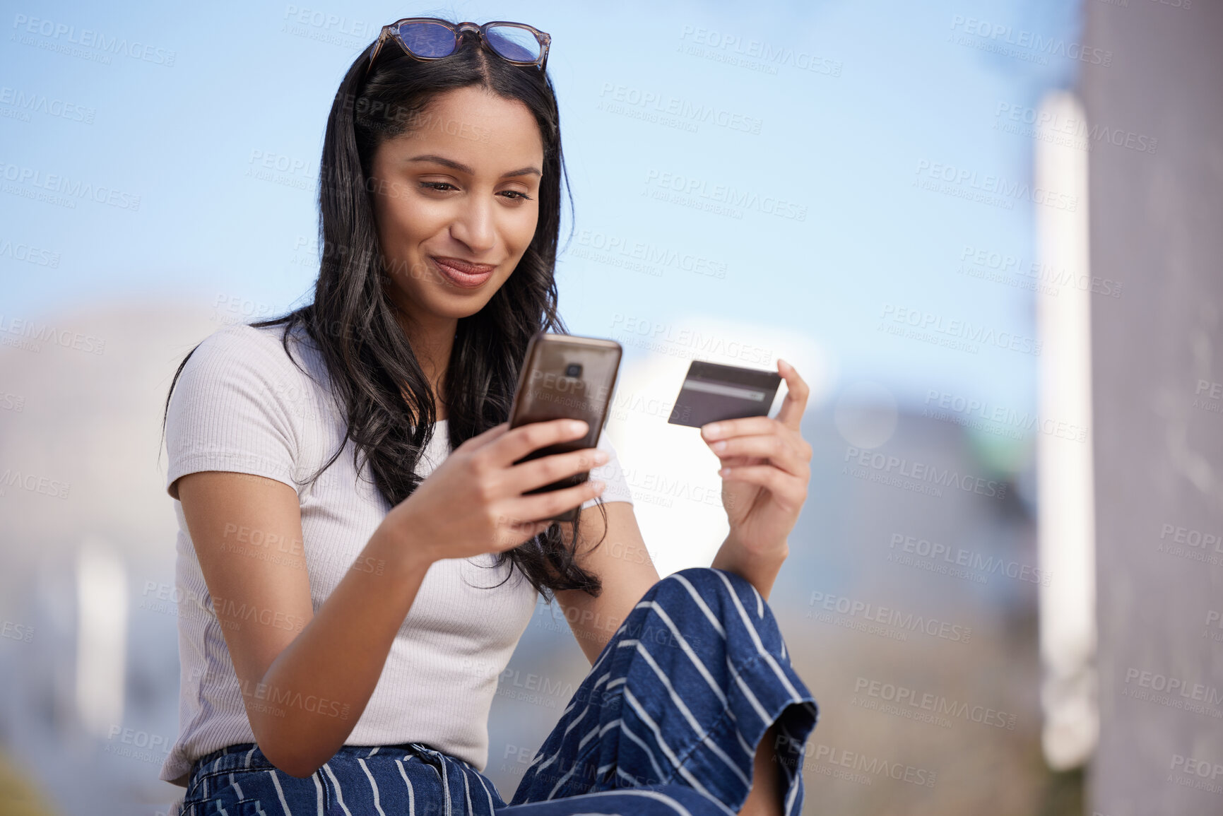 Buy stock photo Shot of a beautiful young student using her phone while sitting outside