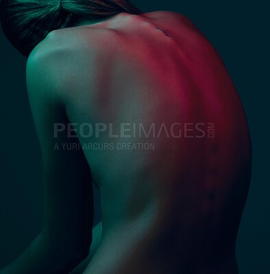 Buy stock photo Back, neon lights and woman with nude, artistic or creativity against a blue studio background. Person, model and natural body with beauty, skincare or art deco for wellness or colorful dermatology