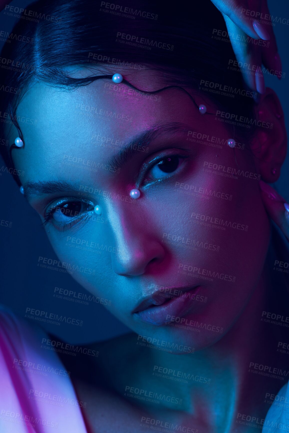 Buy stock photo Cropped portrait of an attractive young woman posing in studio against a blue background