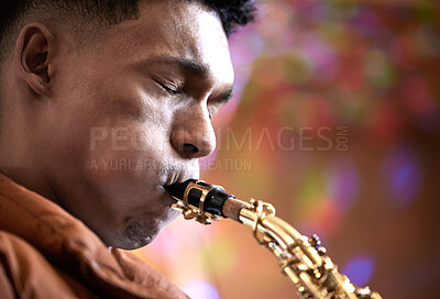 Buy stock photo Cropped shot of a handsome young male musician playing his saxophone at home