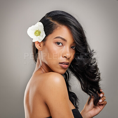 Buy stock photo Shot of a beautiful young woman posing with a flower in her hair