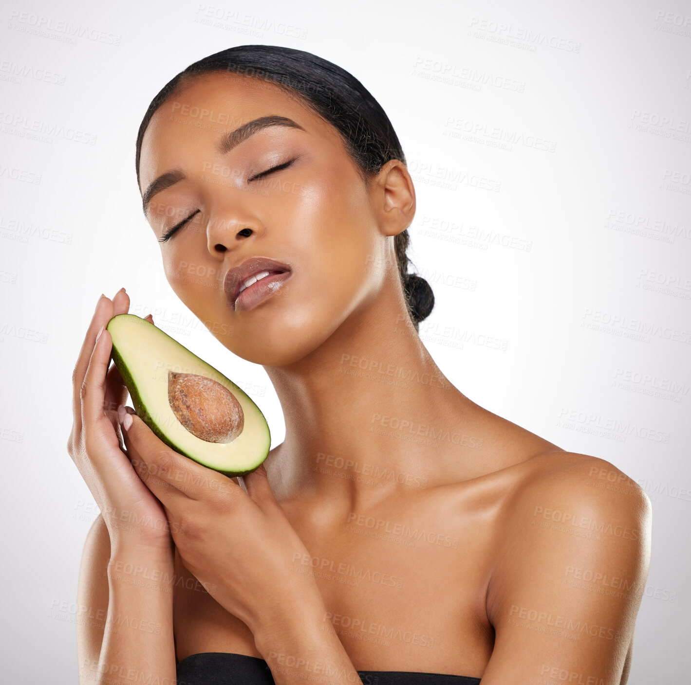 Buy stock photo Skincare, cosmetics and woman with avocado in studio for healthy skin, wellness and nutrition. Female model, face and organic fruit by white background for moisture, nourish and  glowing tone of girl