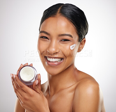 Buy stock photo Studio portrait of an attractive young woman posing with a container of face lotion against a grey background
