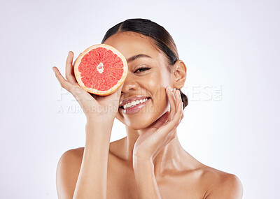 Buy stock photo Woman, portrait and grapefruit for skincare in studio on white background and satisfied with routine. Natural, beauty and smile on confidence with fruit for skin treatment, ingredient and glow