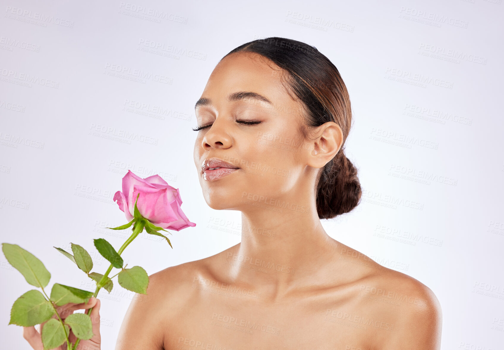 Buy stock photo Rose, scent and woman in beauty with flower for healthy skincare on studio background. Floral, fragrance and girl smell perfume of plant blossom with natural glow on face from cosmetics in spring