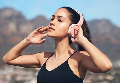 Buy stock photo Shot of a young woman listening to music during a workout