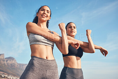 Buy stock photo Shot of two friends stretching before a workout
