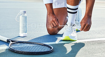 Buy stock photo Cropped shot of an unrecognisable man kneeling down to tie his shoelaces before tennis practice
