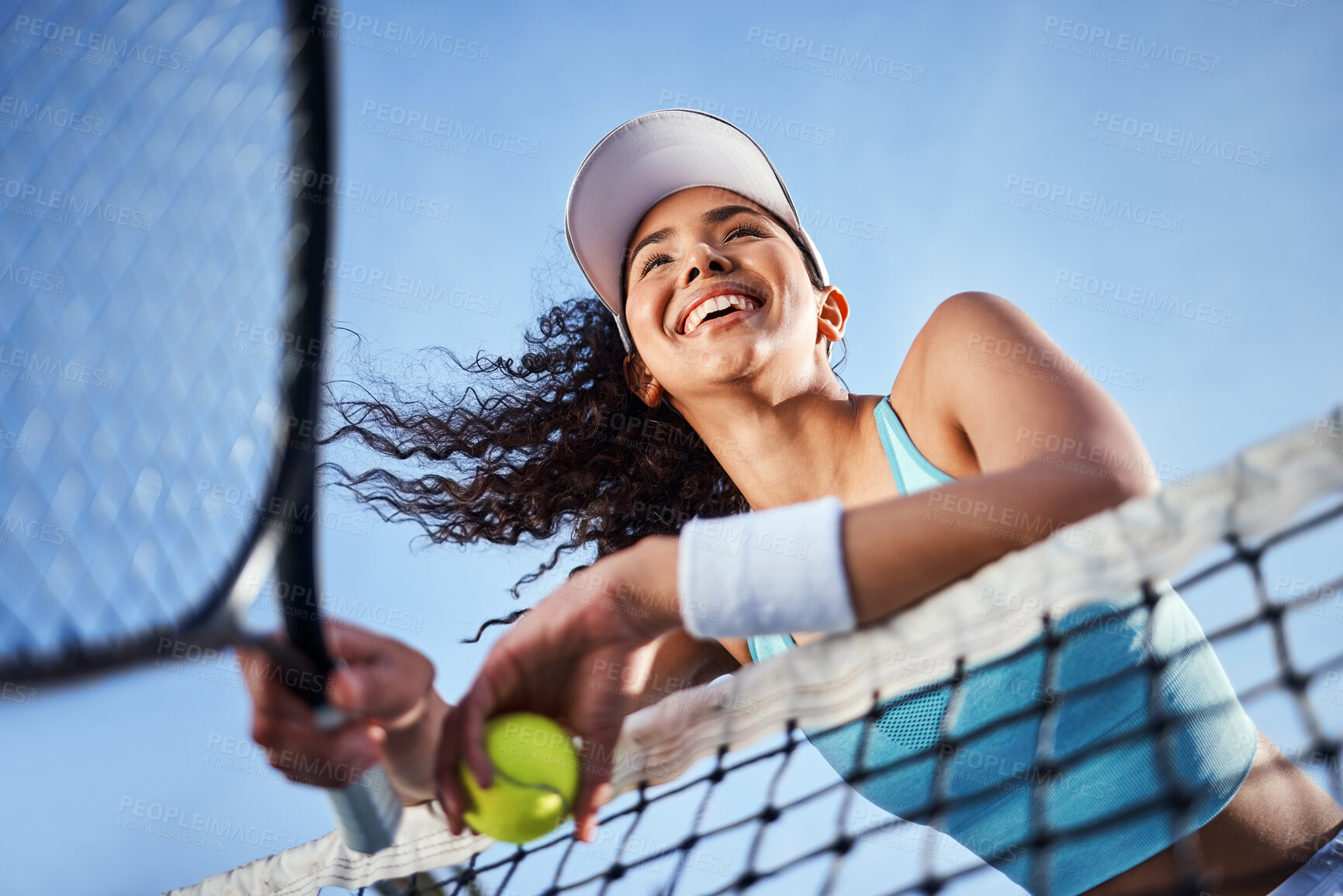 Buy stock photo Low angle shot of an attractive young woman standing alone and leaning on the tennis net during practice