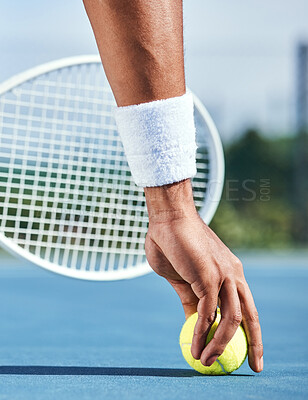 Buy stock photo Cropped shot of an unrecognisable man picking up a tennis ball during practice