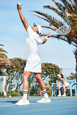 Buy stock photo Full length shot of a handsome young man standing and serving the ball during a tennis match
