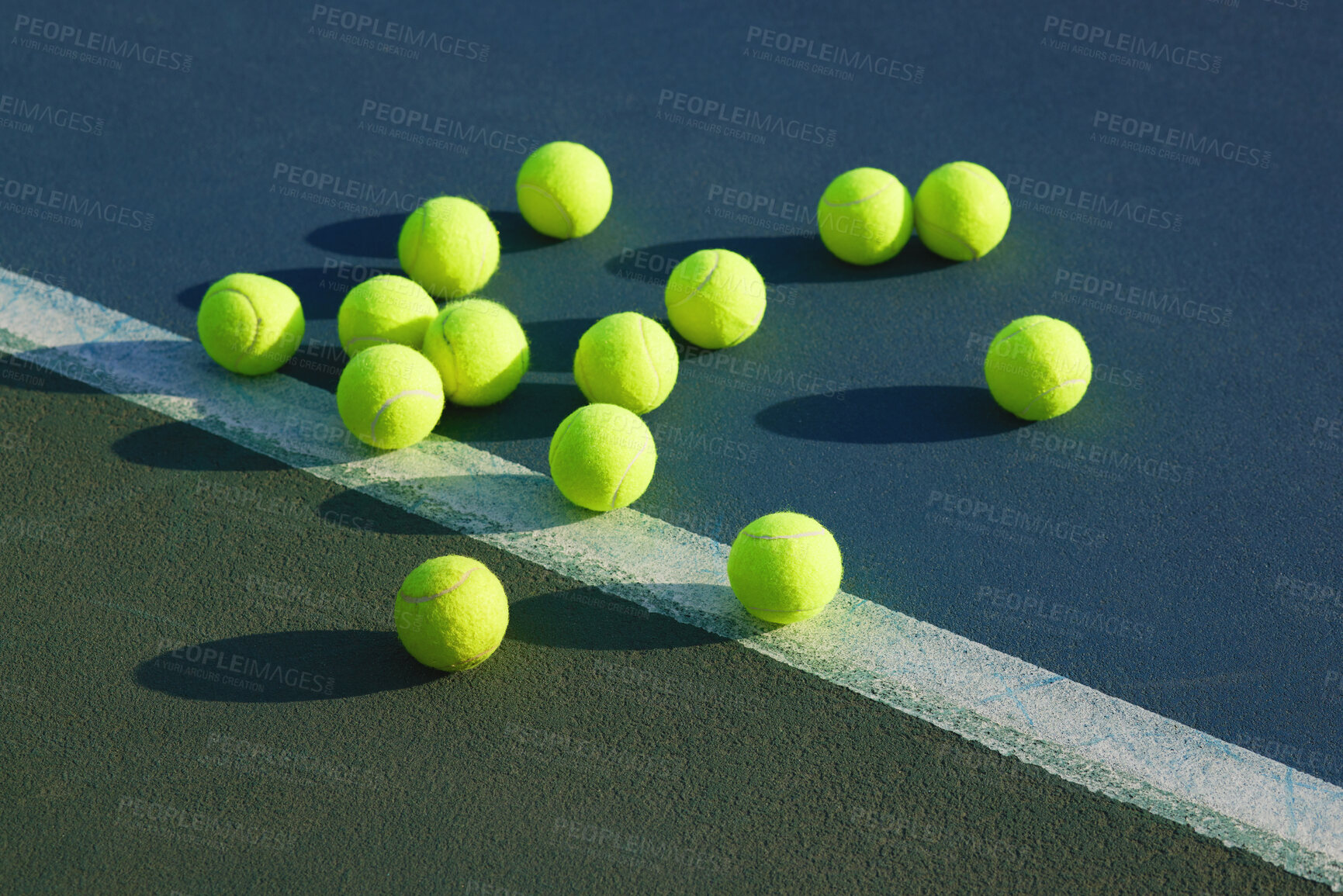 Buy stock photo Shot of an empty tennis court and tennis balls during the day